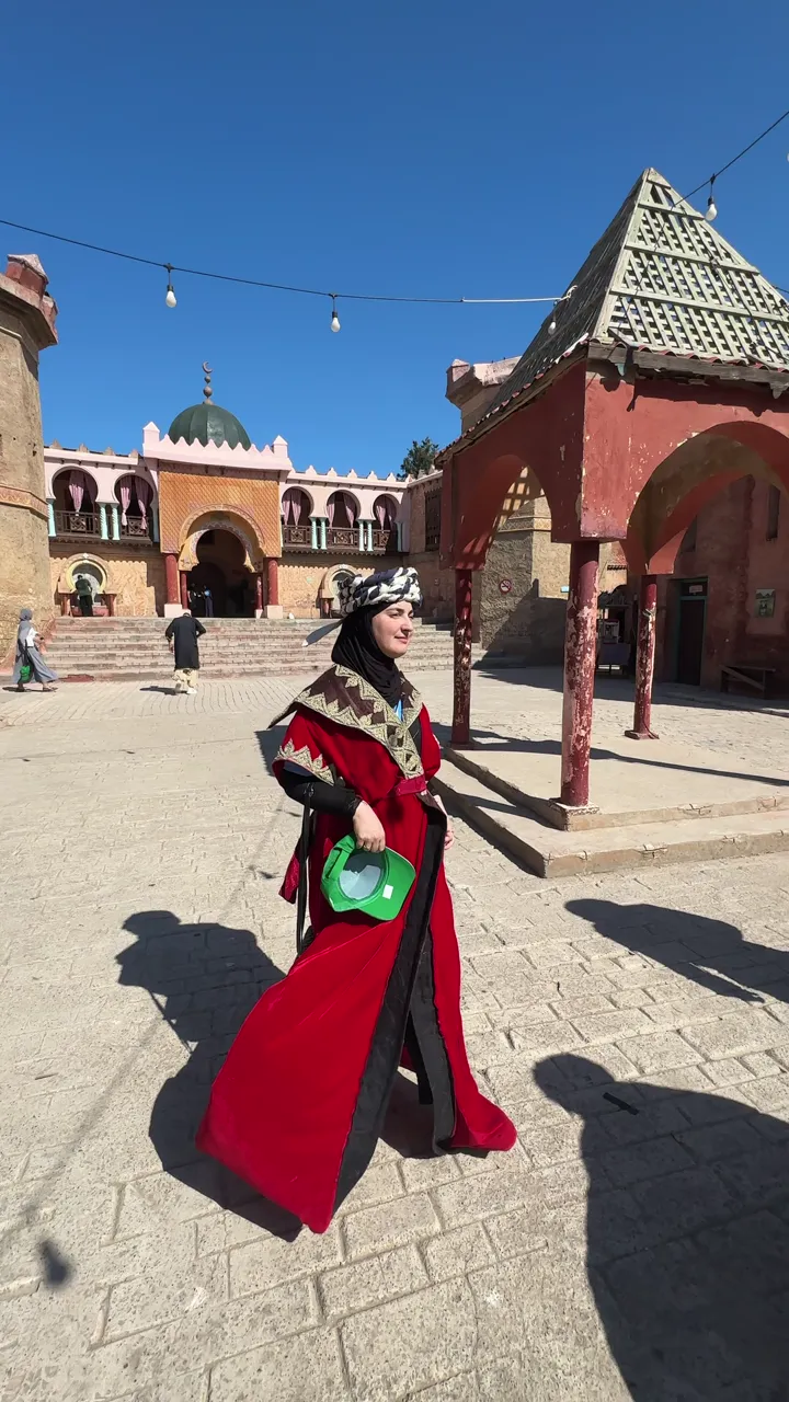 A woman in a traditional red dress in a palace courtyard in Algiers